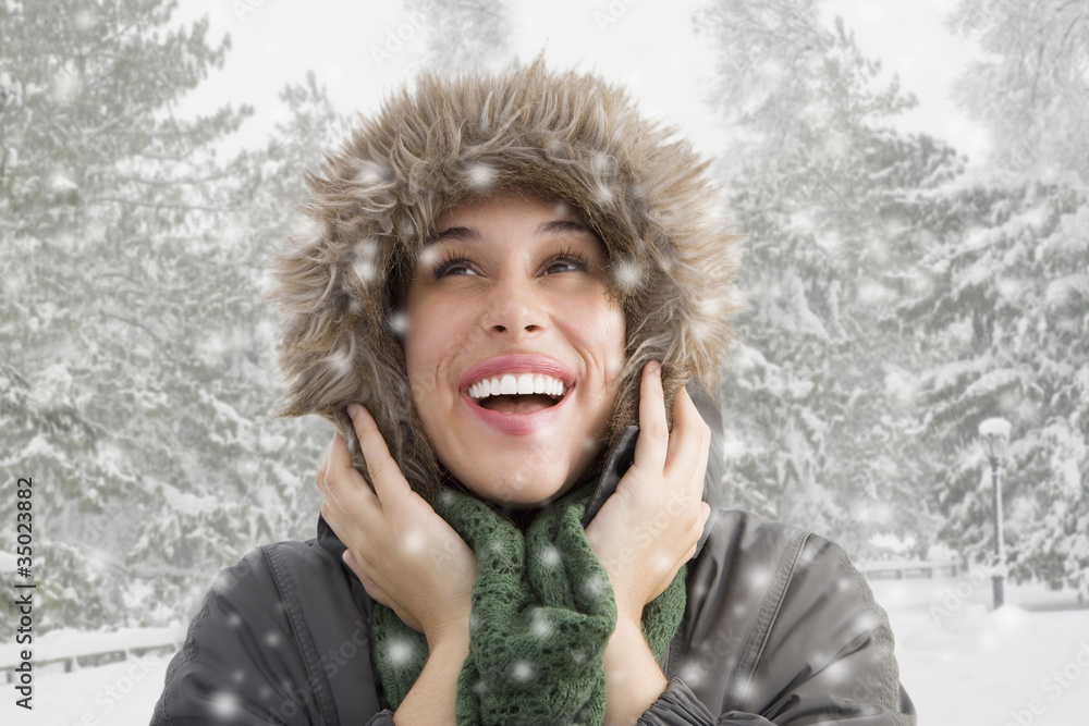 Mixed race woman in fur hood watching snow fall Mixed race woman in fur hood watching snow fall