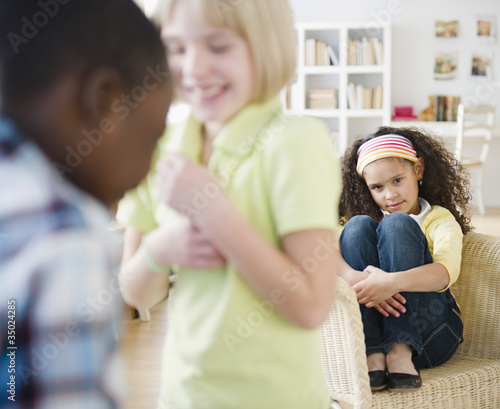 Lonely girl watching friends playing photo