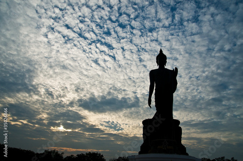 Standing buddha image on beautiful blue sky