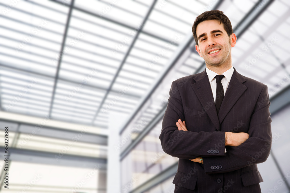 Portrait of an handsome smiling businessman at a modern office b Portrait of an handsome smiling businessman at a modern office b