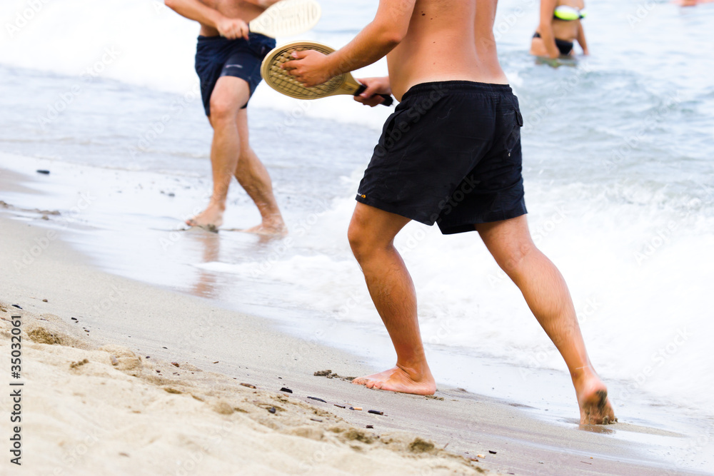 Ragazzo che gioca a racchette in spiaggia