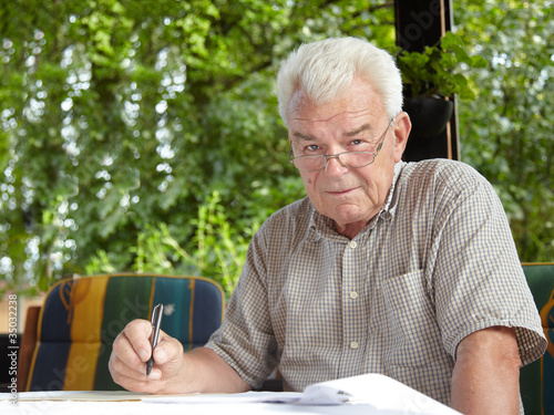 Close up of a happy aged man in the garden photo