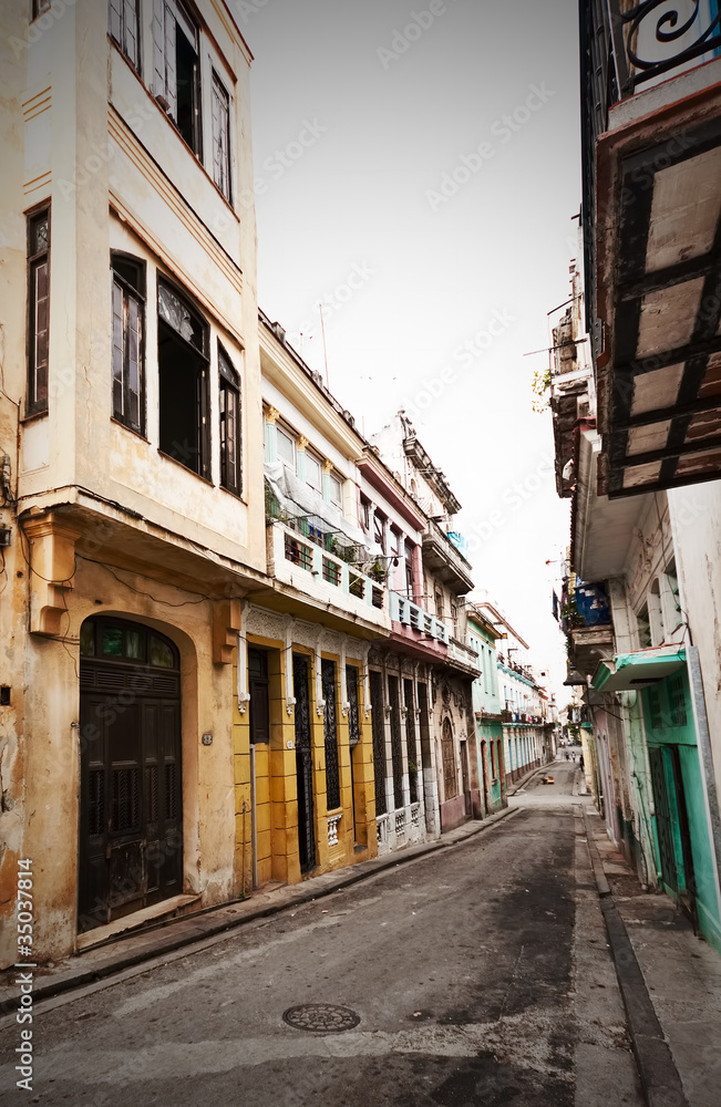 Street in Old Havana sidelined by colorful crumbling buildings