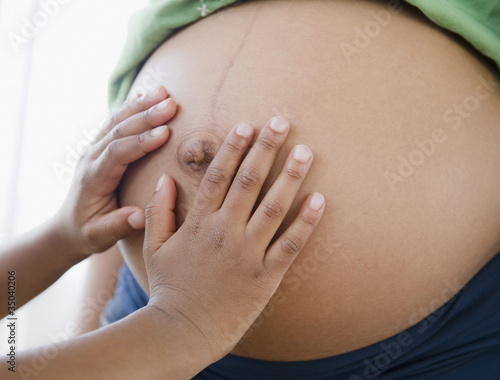 Close up of Black boy touching pregnant mother's stomach