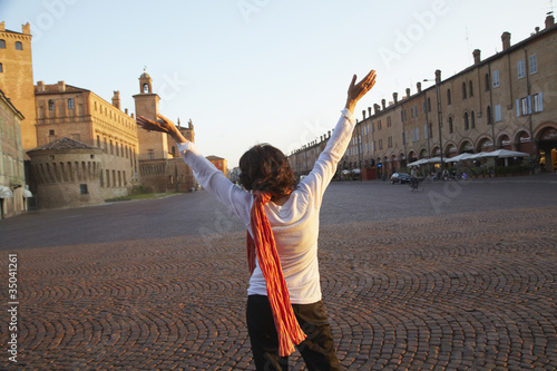 Italian woman with arms raised in piazza photo