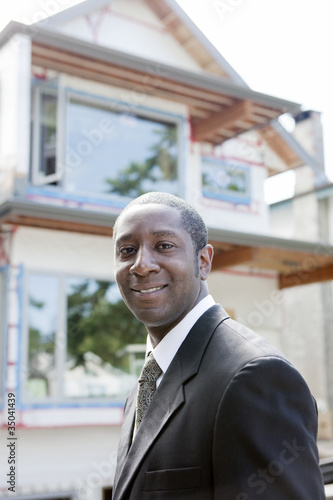 Black real estate agent near house under construction photo