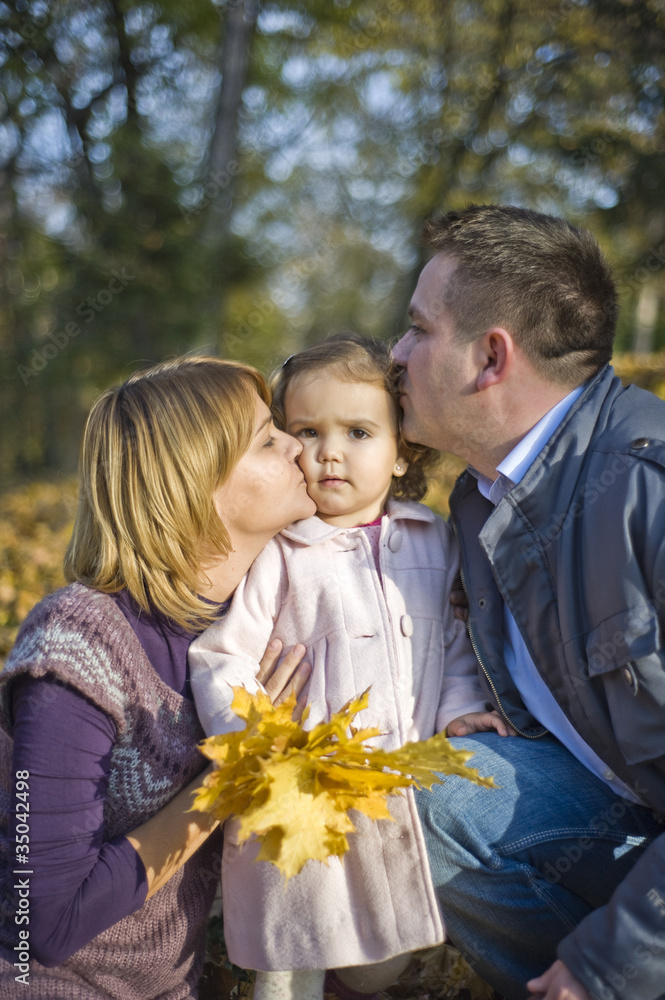 Happy family, mom and dad and little girl in the park Happy family, mom and dad and little girl in the park
