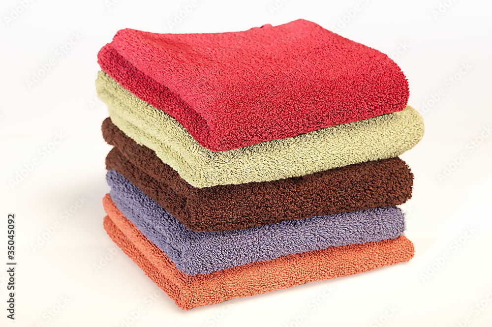 Five bath towels of different colors on white background Five bath towels of different colors on white background