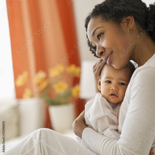 Mixed race woman hugging baby