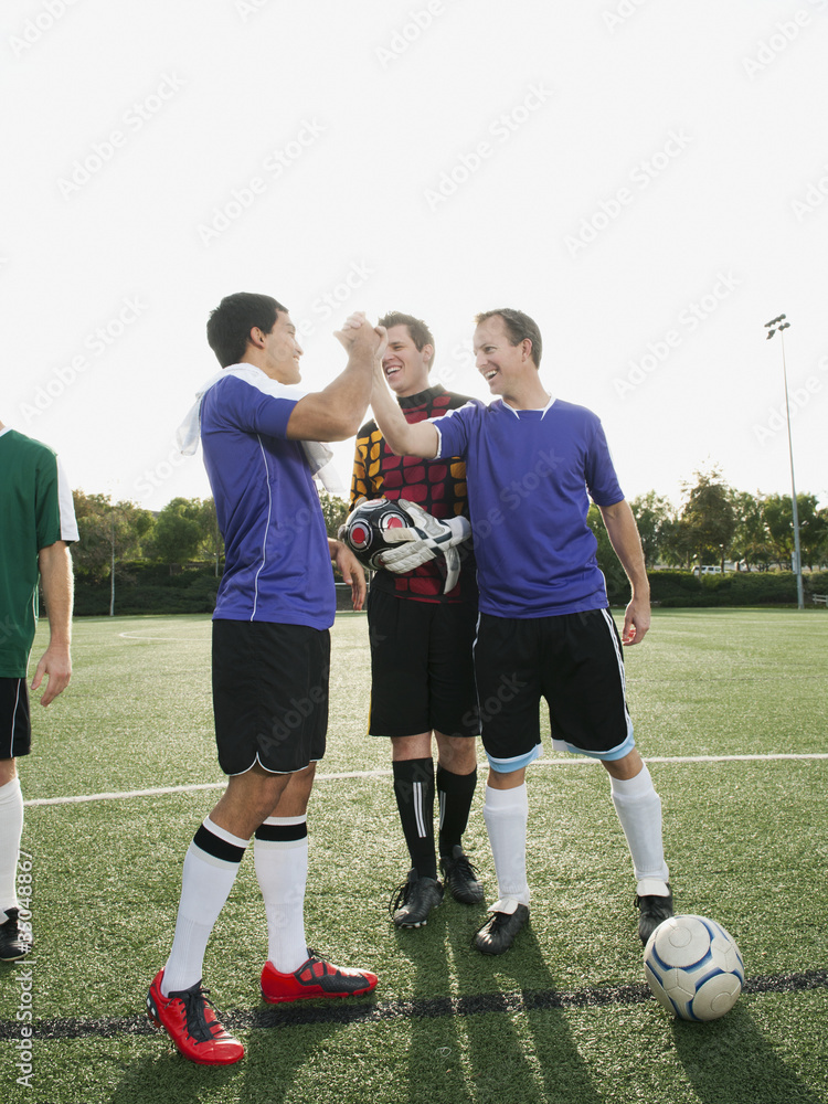 Soccer players cheering on soccer field Soccer players cheering on soccer field
