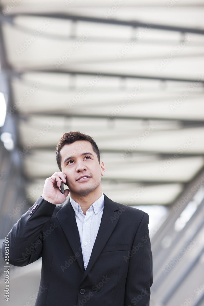 Mixed race businessman talking on cell phone Mixed race businessman talking on cell phone
