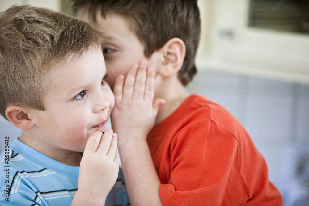 Caucasian brothers whispering together Caucasian brothers whispering together