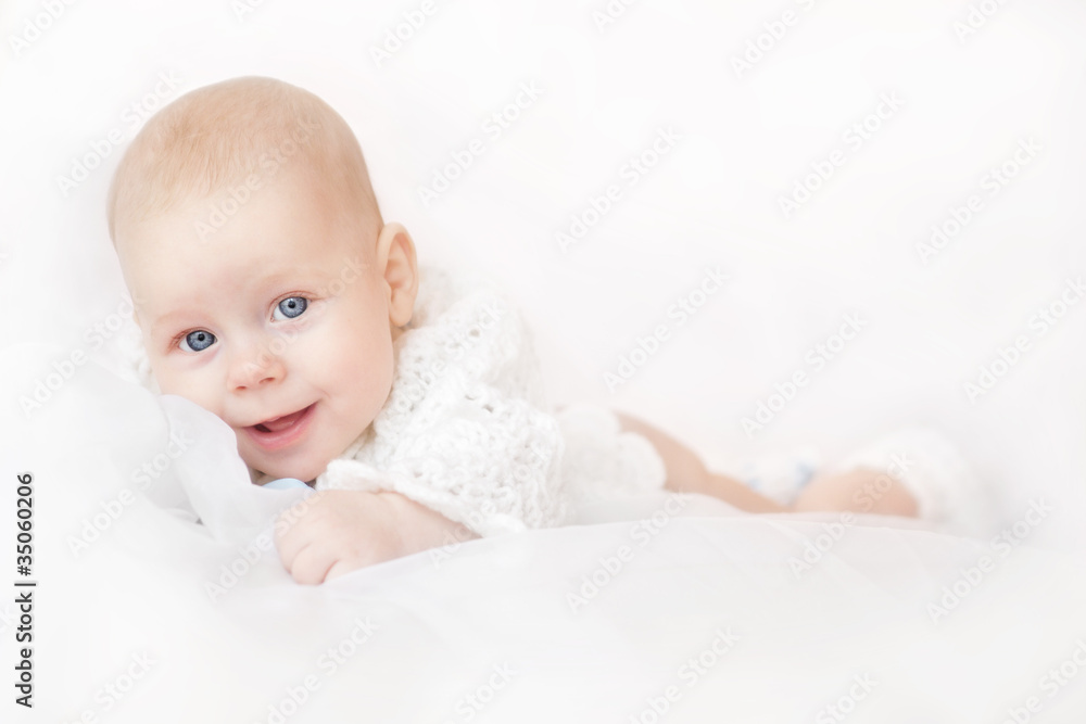 Smiling adorable baby lying over white background