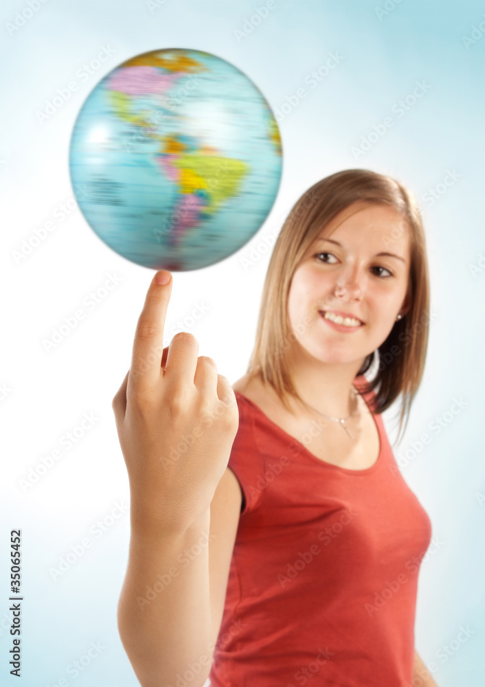 Junge Frau balanciert einen Globus auf dem Finger Junge Frau balanciert einen Globus auf dem Finger