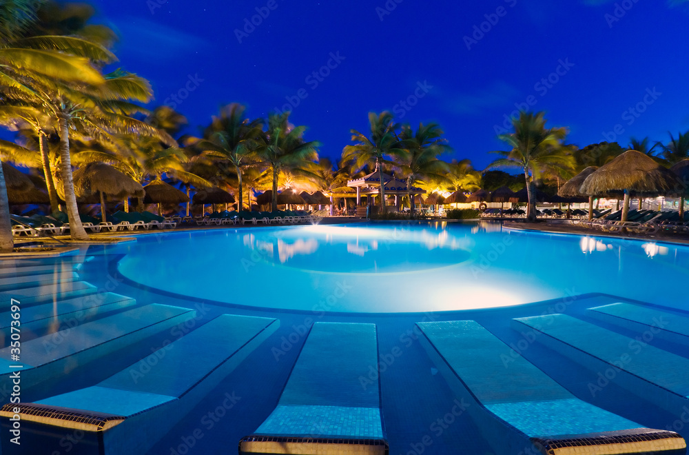 Tropical resort with swimming pool at night
