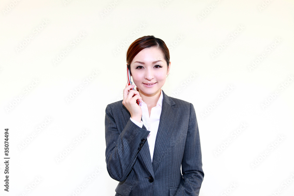 携帯電話を持ち微笑むオフィスレディー