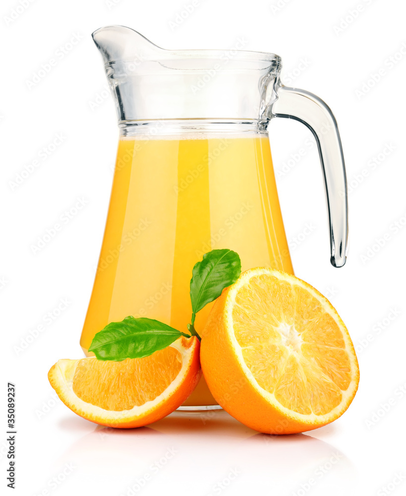 Jug of orange juice and orange fruits with green leaves