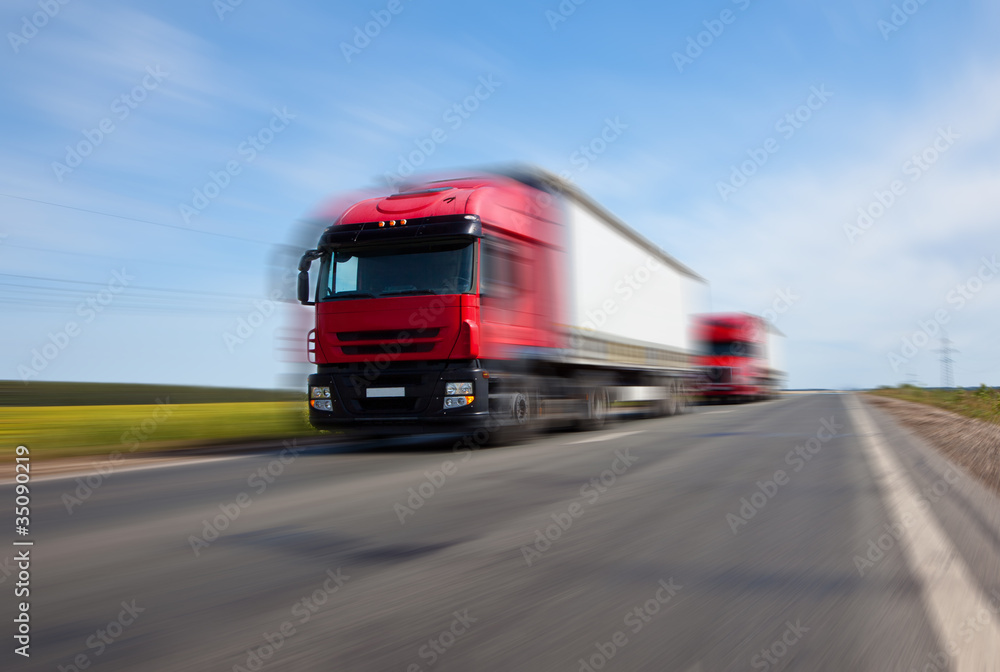 two red trucks blurred motion two red trucks blurred motion