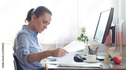 Young businesswoman overwhelmed by too much paperwork