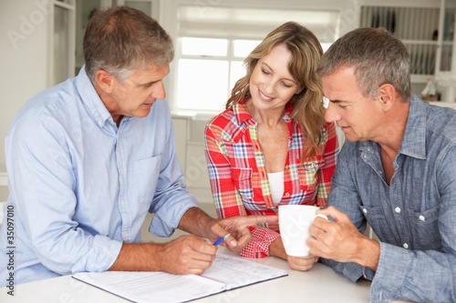 Mid age couple with financial advisor at home