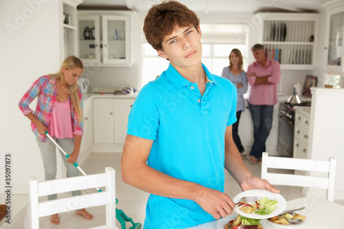 Fotografie Teenagers reluctantly doing housework