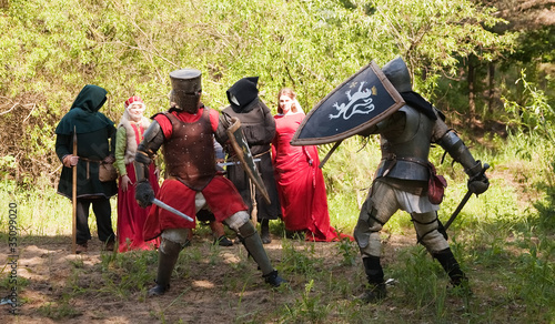 Two knights in armor is fighting photo