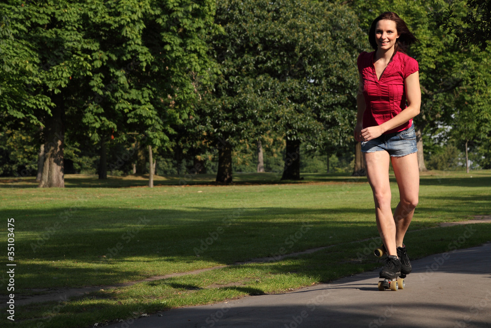 Sexy young woman roller skating in park sunshine Sexy young woman roller skating in park sunshine