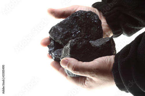 Pieces of coal in hand isolated on white background