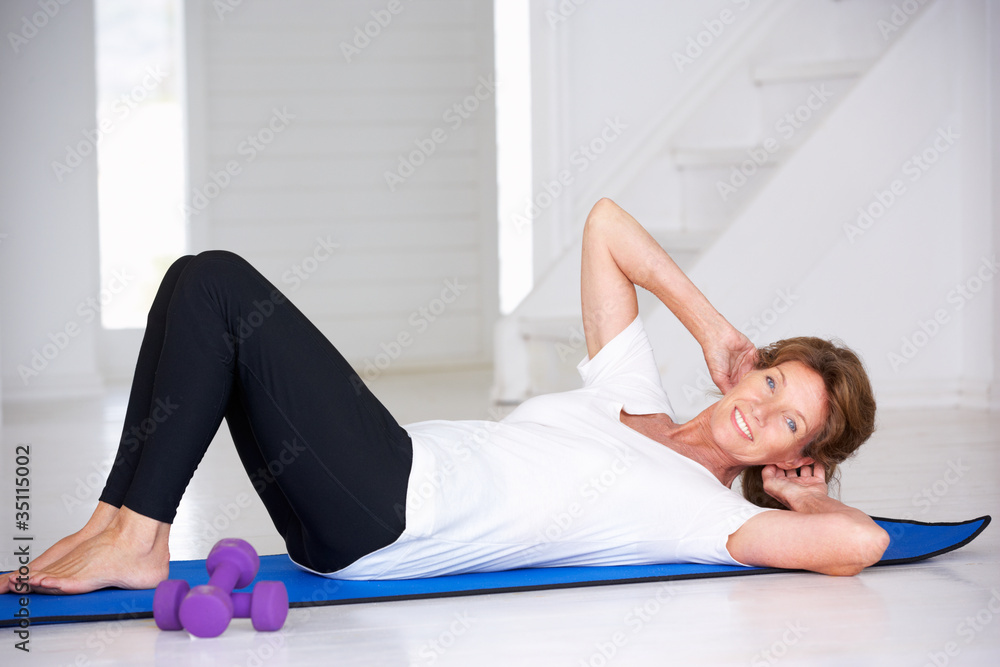 Senior woman doing curl-ups Senior woman doing curl-ups