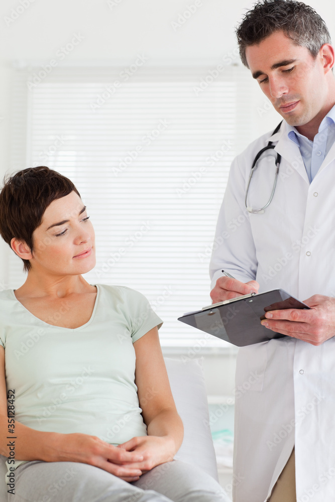 Male Doctor and female patient looking at a chart Male Doctor and female patient looking at a chart
