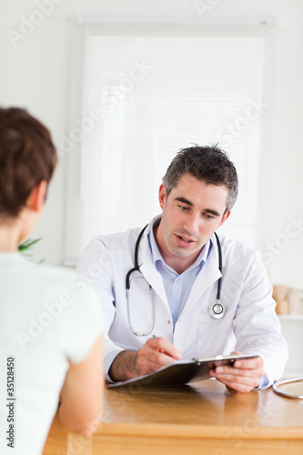 Handsome Doctor talking to a brunette patient