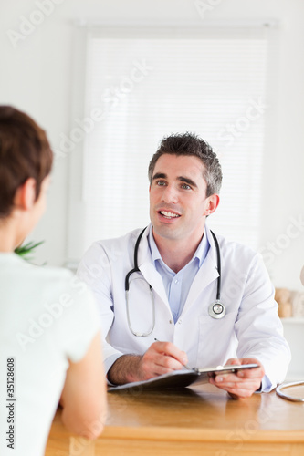Smiling Doctor talking to a brunette patient