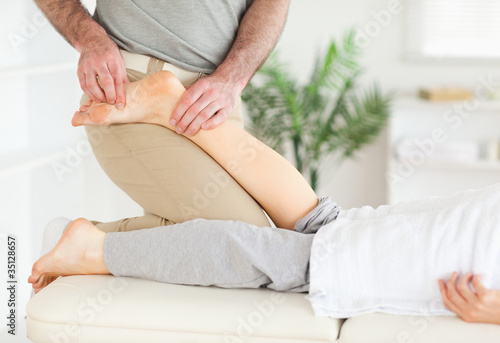 Masseur massaging woman's foot
