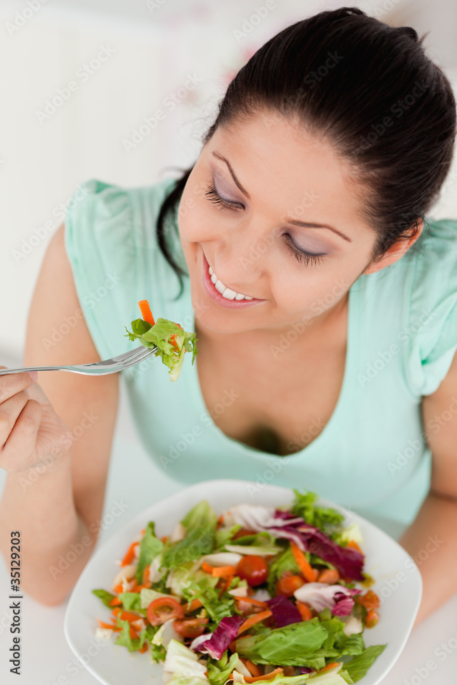 Smiling young female eating salad Smiling young female eating salad