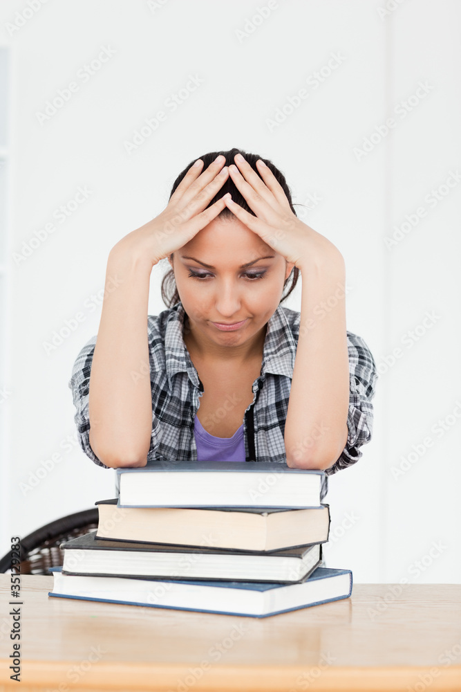 Depressed young student resting on books Depressed young student resting on books