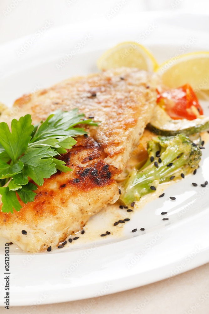 Grilled fish fillet with tomato and lemon