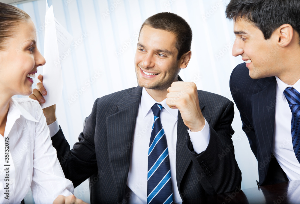 Happy businessman with document and colleagues Happy businessman with document and colleagues