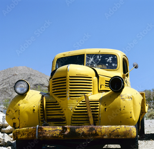 An yellow abandoned Bonnie and Clyde vehicle photo
