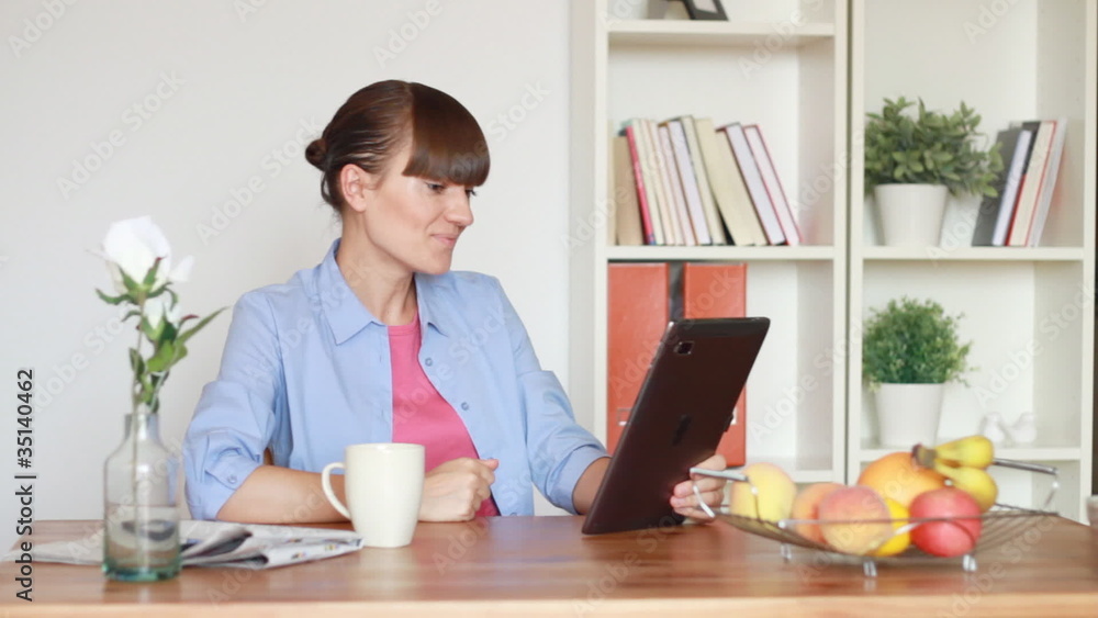 Young woman chatting on tablet computer in home Young woman chatting on tablet computer in home