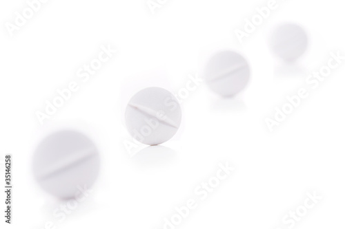 White medical pills on white background.