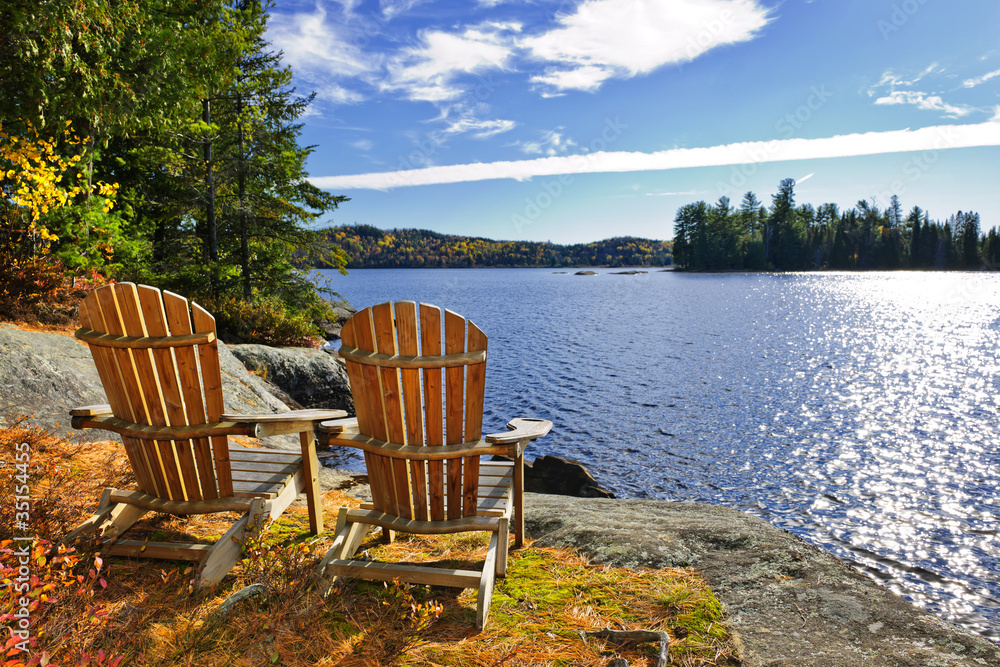 Naklejka premium Adirondack chairs at lake shore