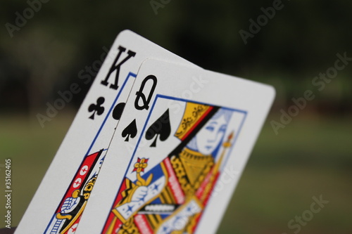 Fotografie The king and the queen cards outdoor with green background