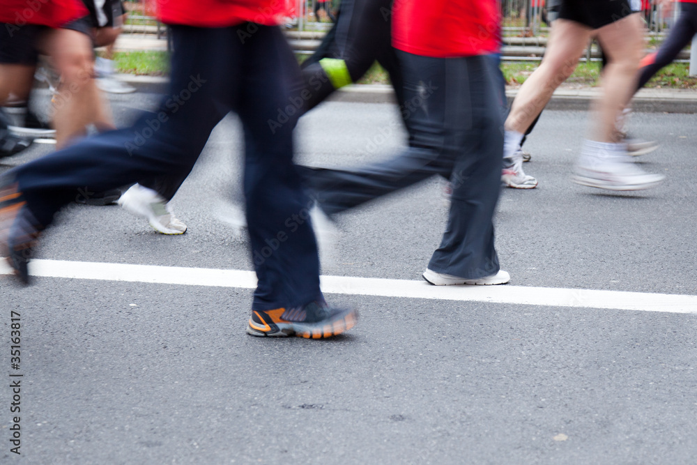 People running in city marathon on a street People running in city marathon on a street