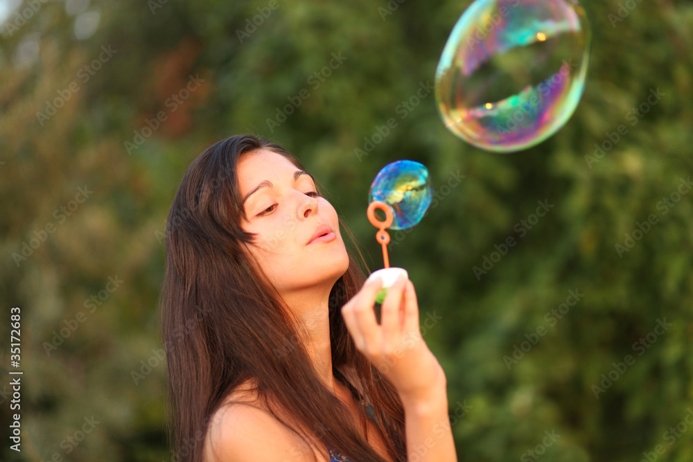 Pretty woman inflating soap-bubbles Pretty woman inflating soap-bubbles