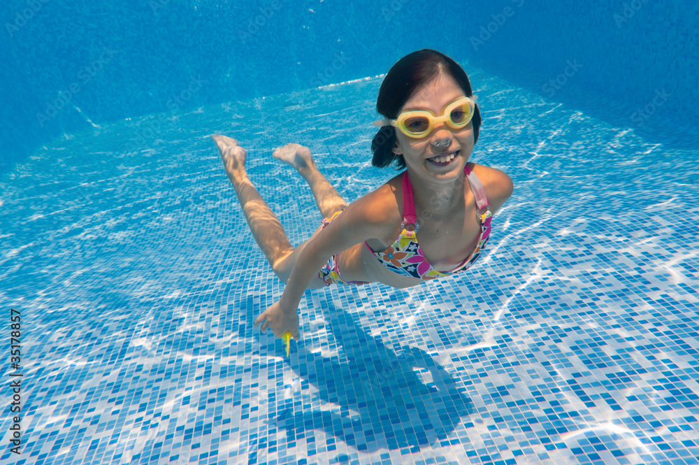 Happy smiling underwater kid in swimming pool