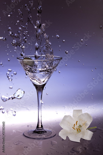 Splashing olive into a martini glass