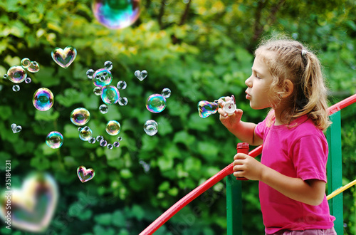 Little girl blowing interesting bubbles