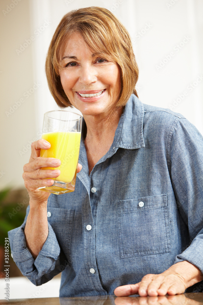 Mid age woman drinking orange juice Mid age woman drinking orange juice