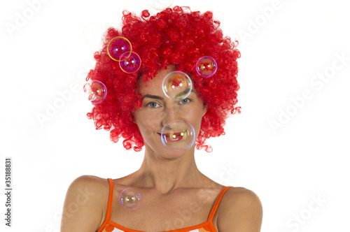 Beautiful woman in an orange wig with soap bubbles