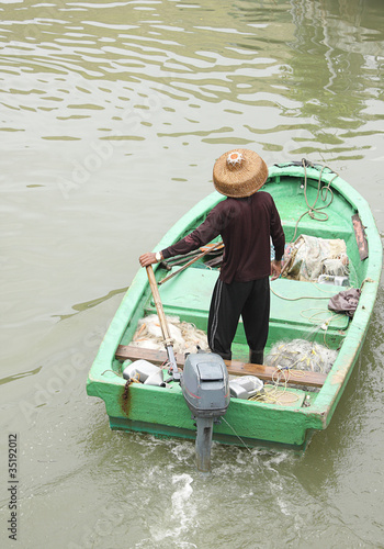 Photo man on sampan boat with outboard motor